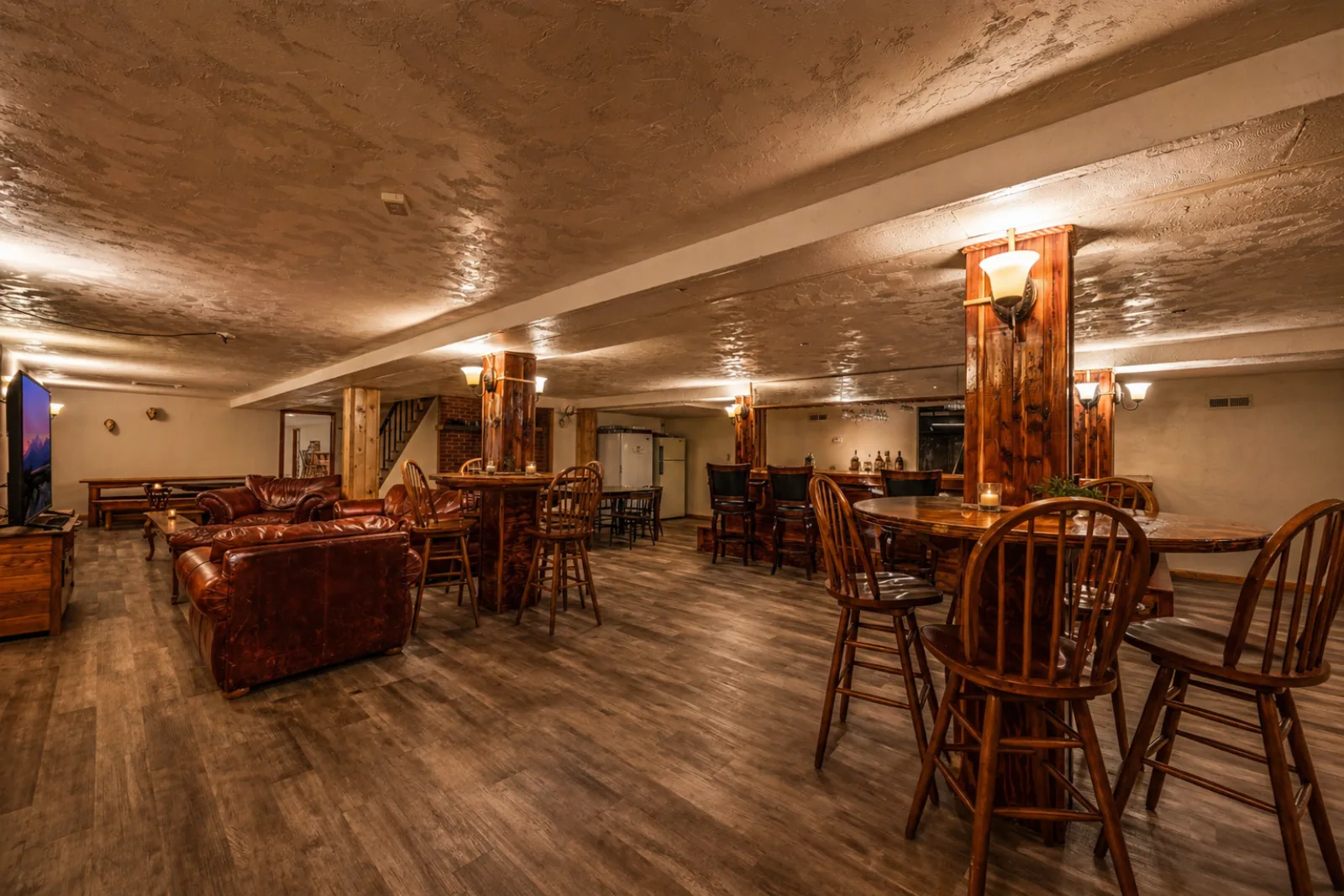Leather club chairs and gathering tables spanning the Harbour Hideout lounge.